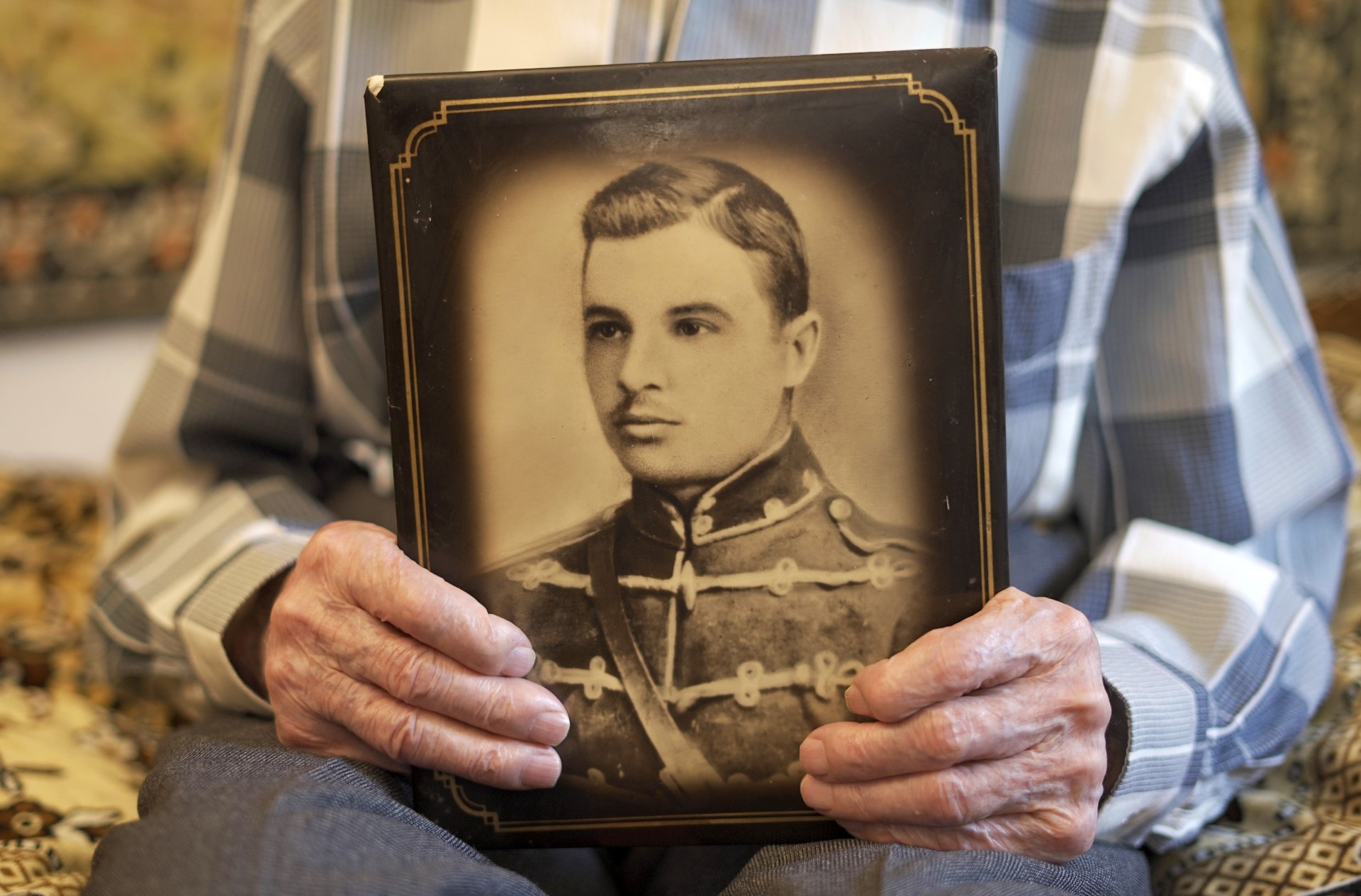 Дмитро Винярський тримає фотопортрет свого батька, Дениса Афанасійовича Винярського, знятий під час служби останнього в армії. 
