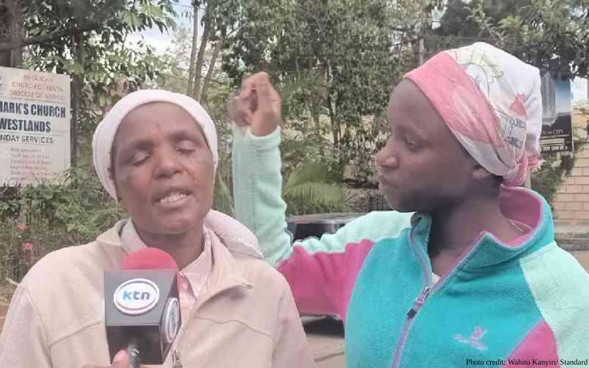 Two women, one wearing a white headscarf and beige jacket holding a KTN-branded microphone, and another in a turquoise and pink jacket with pink headscarf raising her hand, speak outdoors with greenery and a church sign visible in the background, photographed by Wahito Kanyiri for The Standard.