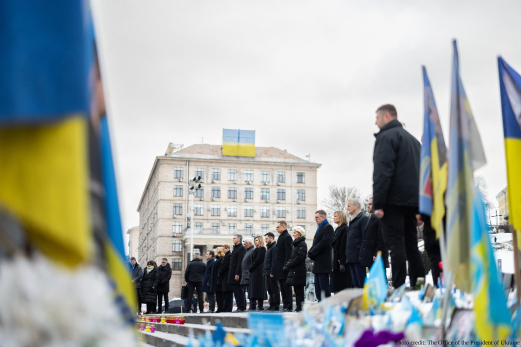 President Volodymyr Zelenskyy, First Lady Olena Zelenska, and senior Ukrainian officials (Denys Shmyhal, Ruslan Stefanchuk, and Andriy Yermak) stand in a solemn line alongside international leaders during a commemoration ceremony in Kyiv. At the People’s Memorial of National Remembrance at Maidan Nezalezhnosti, respect was paid to the fallen warriors by President of Finland Alexander Stubb, President of the European Council António Costa, President of the European Commission Ursula von der Leyen, Prime Minister of Denmark Mette Frederiksen, Prime Minister of Estonia Kristen Michal, Prime Minister of Iceland Kristrún Frostadóttir, Prime Minister of Latvia Evika Siliņa, Prime Minister of Norway Jonas Gahr Støre, Prime Minister of Croatia Andrej Plenković, Prime Minister of Sweden Ulf Kristersson, as well as representatives from the governments of the United Kingdom, Lithuania, North Macedonia, Poland, and Croatia, Special Envoy of the President of France, parliamentarians, and European Commissioners. Ukrainian flags are visible in the foreground.