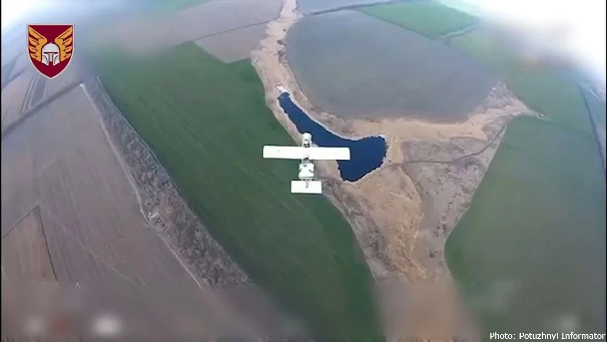 An aerial view captured by a camera on a Russian Molniya drone shows the aircraft flying over green and brown agricultural fields and a small pond. A white Starlink terminal is visibly mounted on the top of the drone's fuselage to provide stable satellite communications for long-range operations.