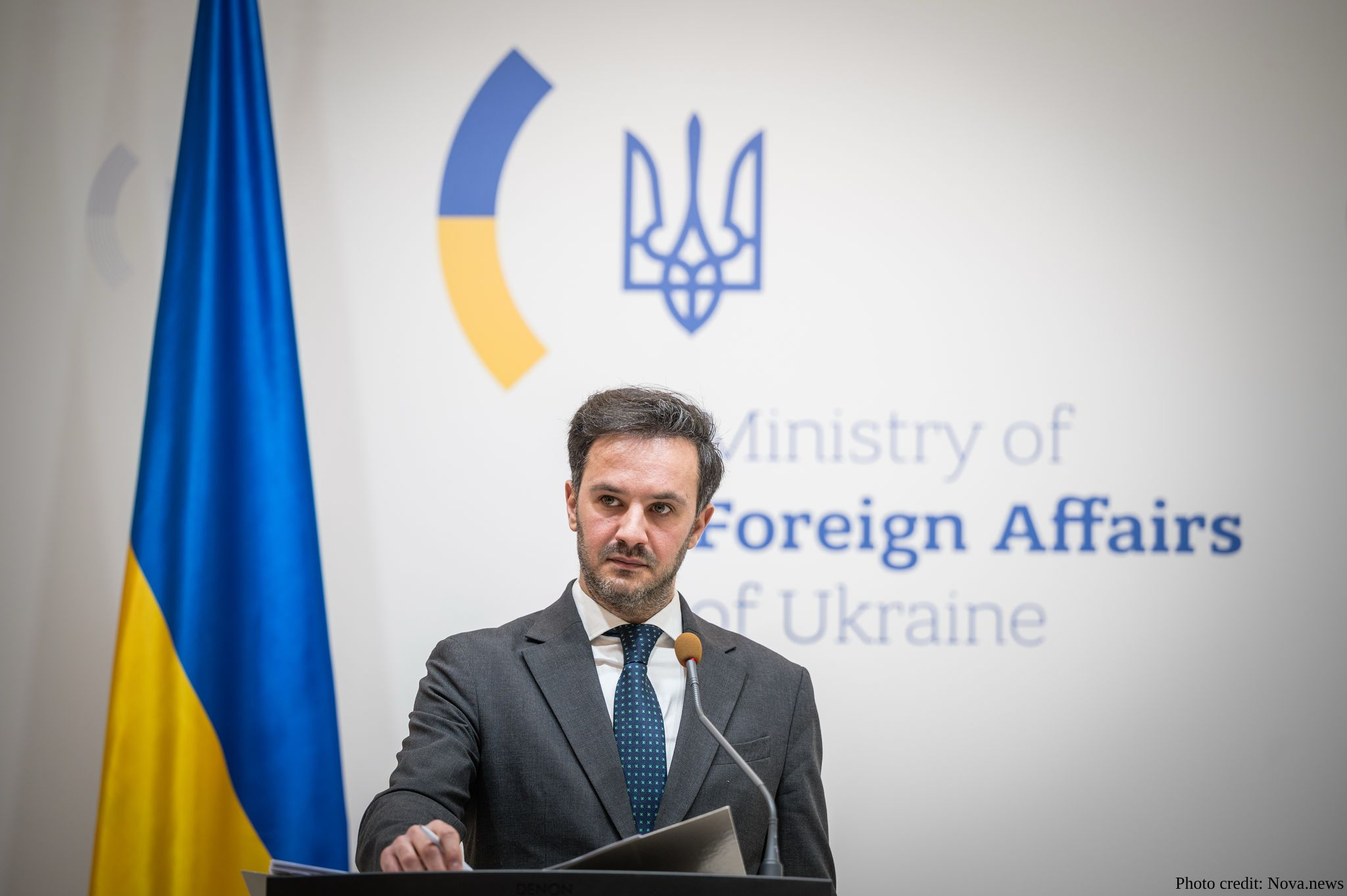 Heorhii Tykhyi, spokesperson for the Ministry of Foreign Affairs of Ukraine, stands at a lectern during a press briefing. The Ukrainian flag and the ministry's official logo and name are visible in the background.