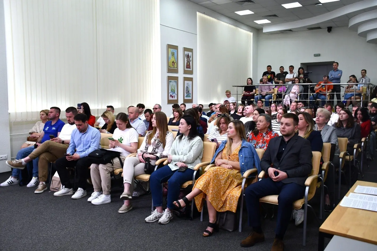 У конференц-залі кілька десятків людей сидять у рядах крісел і слухають виступи правозахисників; частина присутніх користується телефонами, а позаду стоять журналісти та оператори.